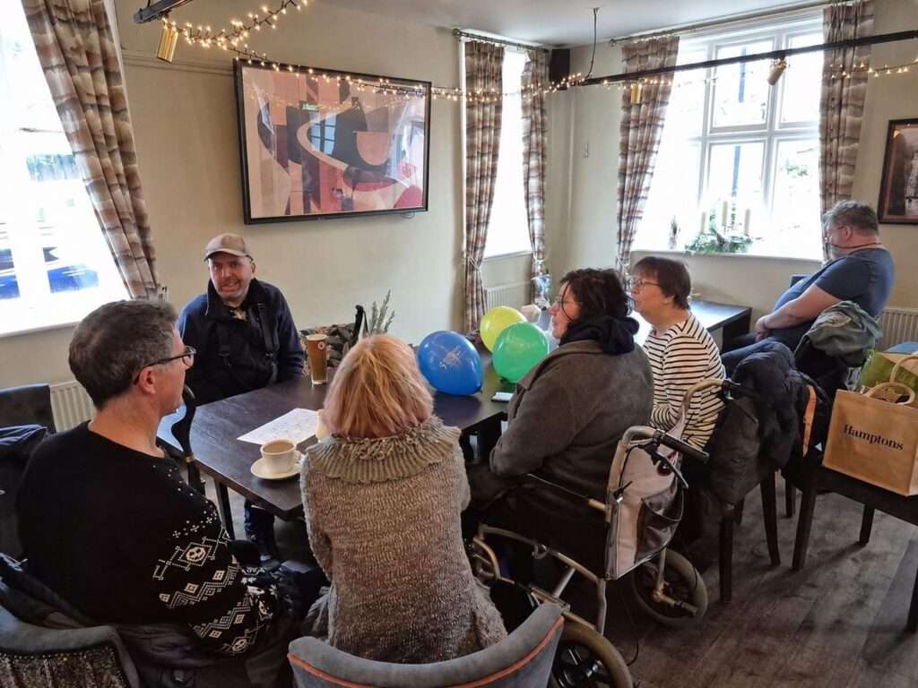 Members of the West Kent group in a pub around a table.