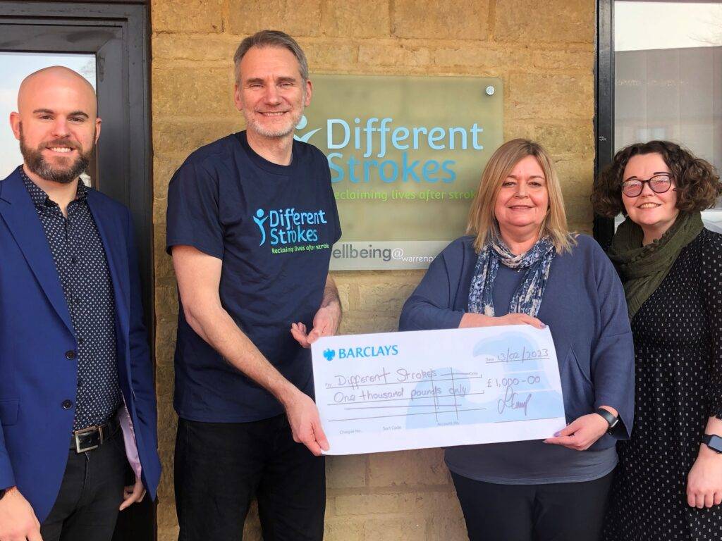Mark, Austin, Jane and Emma are pictured smiling standing outside Different Strokes office in Milton Keynes. Jane is handing Austin a cheque for £1,000 from Freightliner